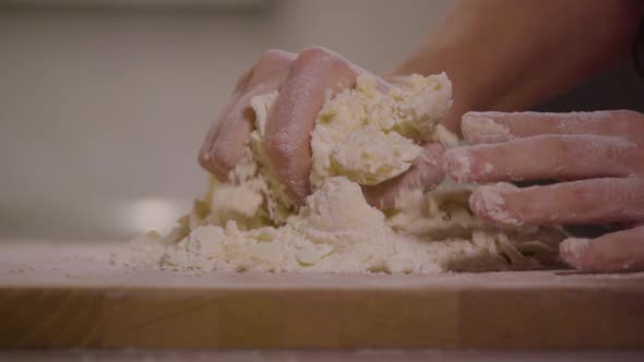A Woman Kneads Crumbly Pastry Dough on a Kitchen Counter - Closeup - Slow Motion