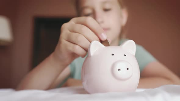 Girl Putting Coin in Piggy Bank Saving Money Concept