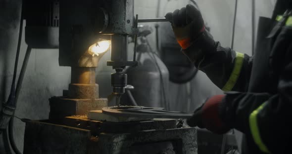 Metalworker in Safety Uniform Drills Steel Detail on a Vertical Drilling Machine at Workshop