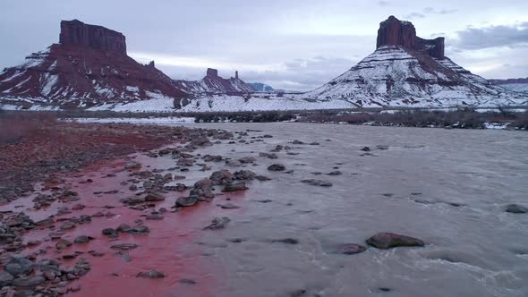 Flying over the Colorado River as snow melts moving red dirt