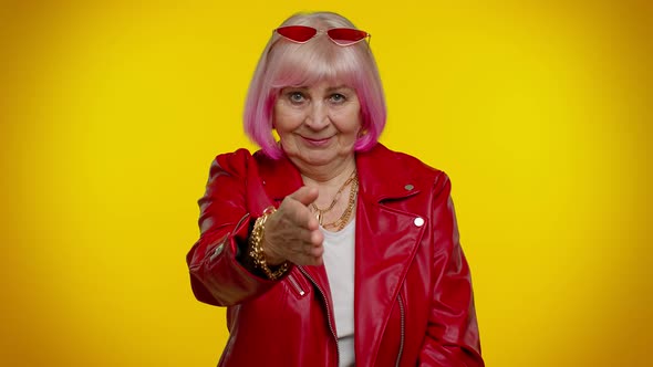 Friendly Senior Woman Outstretching Hand to Camera Offering Handshake Greeting with Kind Smile