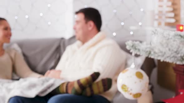 Inlove Couple Sitting on the Sofa in Christmas Decorated Room