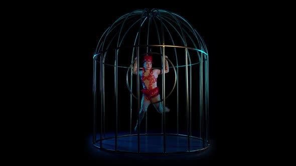 Aerial Acrobatics on a Rotating Hoop in a Metal Cage. Black Background