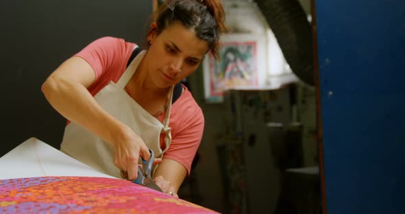 Woman cutting fabric for surfboard 4k