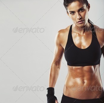 ng woman bodybuilder with muscular body looking at camera with copyspace