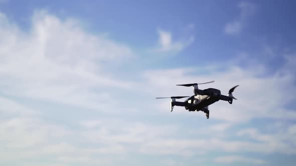 A Small Drone Hovered in the Sky at Sunset, Against the Clouds. Professional Aerial Photography