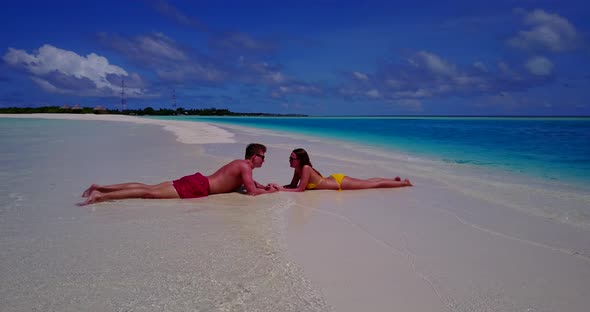 Fun people on romantic honeymoon enjoy life on beach on clean white sand background 