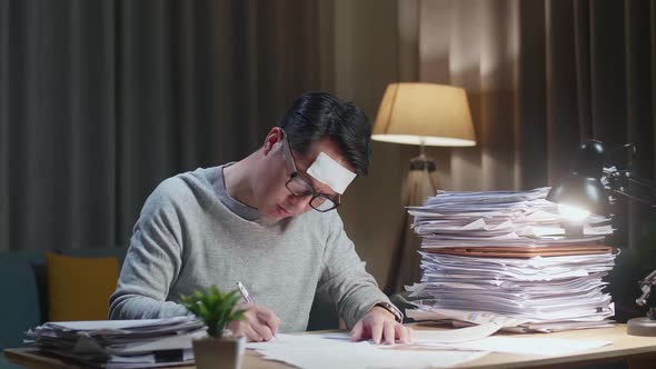 Sick Asian Man Working Hard With Documents At The Home