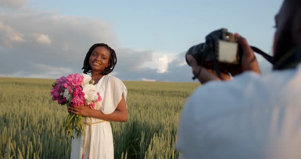 Happy Couple with Camera at Summer Field