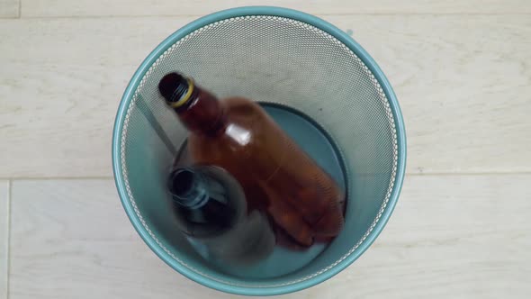 Five Plastic Bottles of Different Colors and Volumes in Turn Fall Into the Office Trash Can