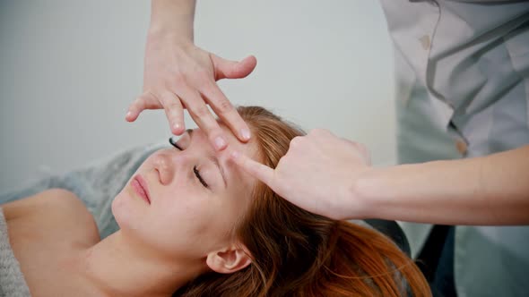 Massage - Woman Massage Therapist Massaging the Face of a Red-haired Woman with Her Hands