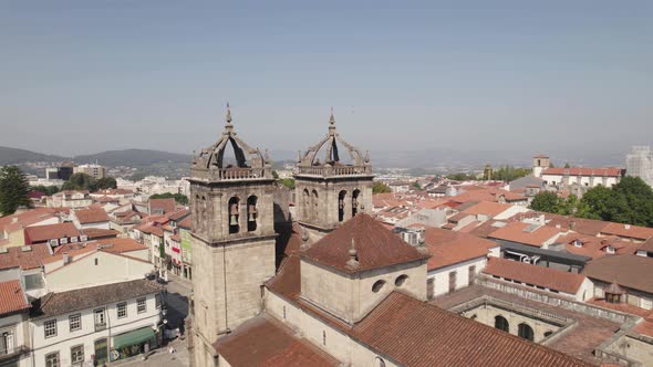 Aerial circular view of Braga historical center with focus on cathedral bell towers and roofs.