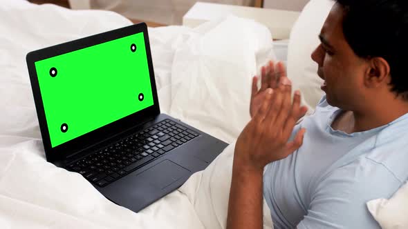 Happy Man with Laptop in Bed Having Video Call