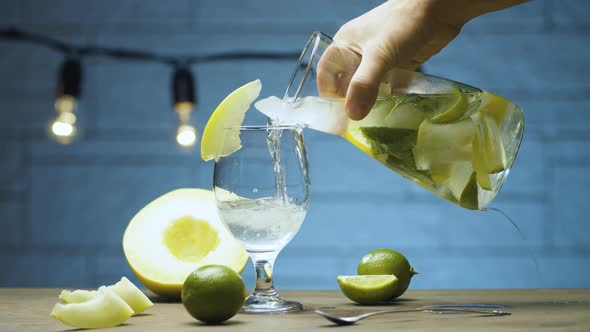 Pouring melon lemonade into a glass