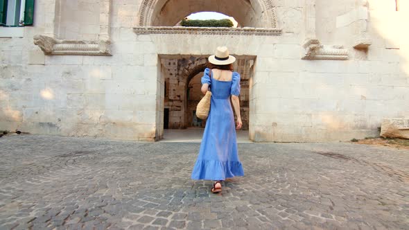 Young girl in a blue dress walking on the street in the city, video 6k