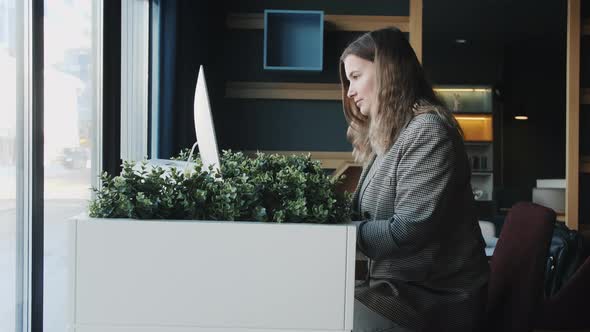 Successful Smiling Businesswoman Uses Laptop and Computer Used in the Office