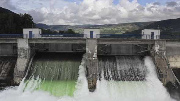 Drone Shot Of Man Crossing Bridge Of Hydroelectric Dam
