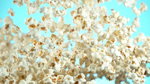 Super Slow Motion Shot of Popcorn on Blue Background After Being Exploded at 1000Fps