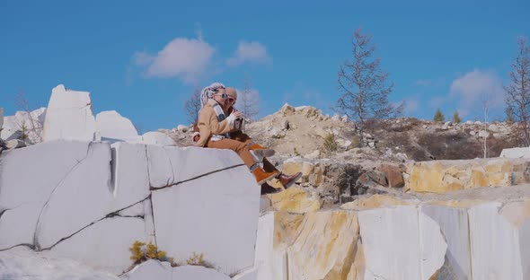 The girl with the bionic hand and her boyfriend are sitting on the grant stones Bionics Baikal