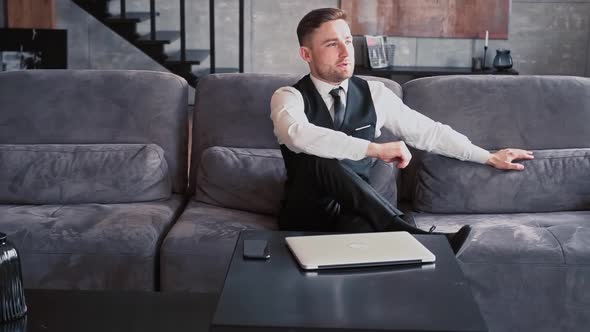 A Professional Sits in a Beautiful Dark Office in Front of a Laptop