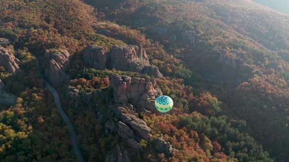 Hot air balloon flying over picturesque rock formation