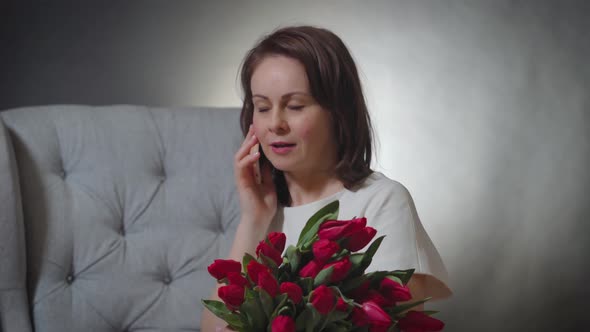 Woman with a Bouquet of Tulips Talking on the Phone