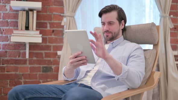 Casual Young Man Using Tablet on Sofa