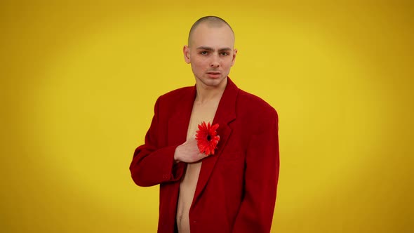 Charismatic Young Man in Jacket Posing with Red Flower at Yellow Background