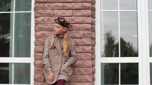 Pensive Teenage Girl in Beret Leaning at Brick Wall