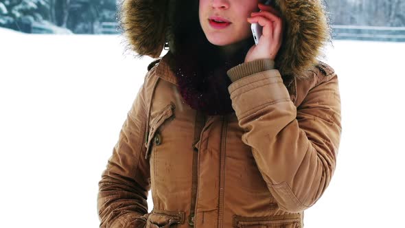 Smiling woman in fur jacket talking on mobile phone