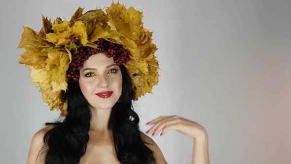 Beautiful Black Haired Girl with Bright Autumn Wreath of Leaves and Flowers in Studio Smiling and