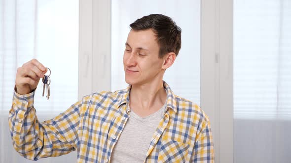 Man in Checkered Shirt Shakes Keys To New Apartment in Room