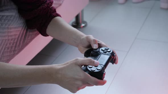 Hands holding controller playing video games