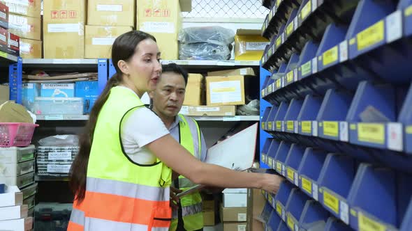 Warehouse Manager and female warehouse clerk counting the small parts stored