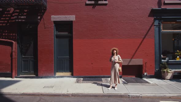 Young tourist with a retro camera at the red house in New York