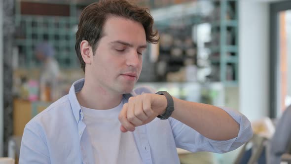 Portrait of Young Man Talking on Smartwatch