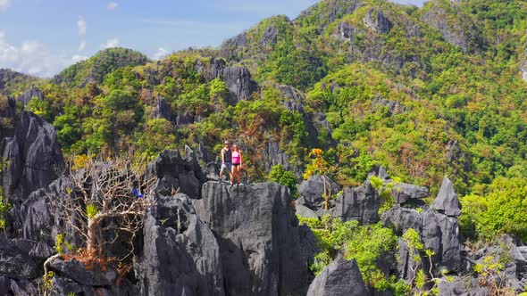 Couple Family Traveling Together on Cliff Edge Taraw in El Nido, Philippines. Man and Woman