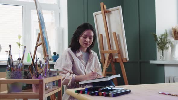 A Woman Artist Sketches in an Art Studio