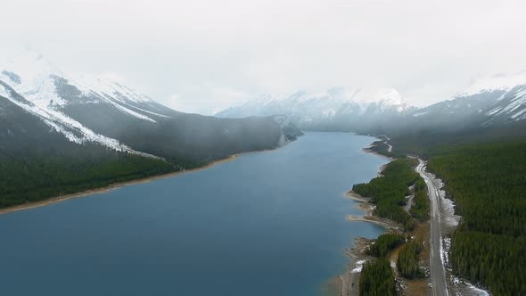 Aerial video showing view of Spray Lakes Reservoir between mountains with peaks in Alberta, Canada