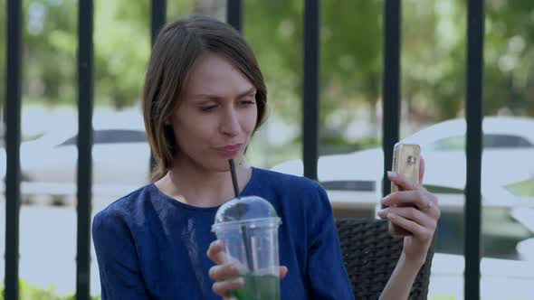 The Girl on the Terrace in the Cafe Taking a Selfie