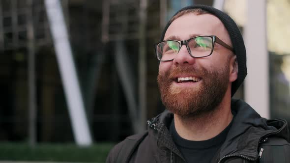 Close Up View of Cheerful Guy in Glasses Having Good Mood and Smiling While Walking at City Street