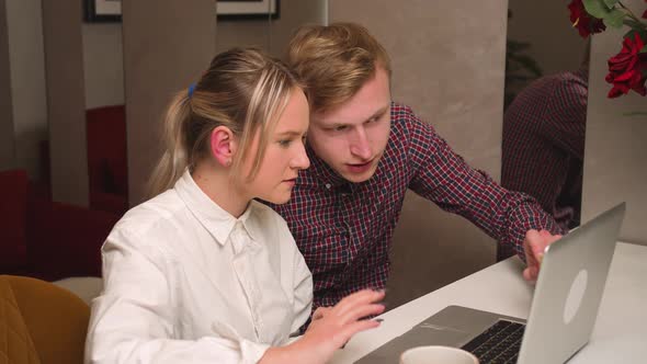 A Man and Woman Students Working on a Laptop at Home Office