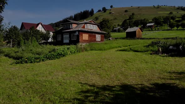 Wooden House on Green Meadow in Mountains