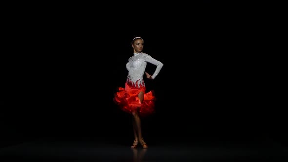 Girl Dancing Rumba in a Studio on a Dark Background