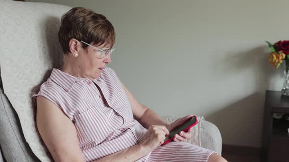 Side View of a Senior Retired Woman Using Smart Phone at Home