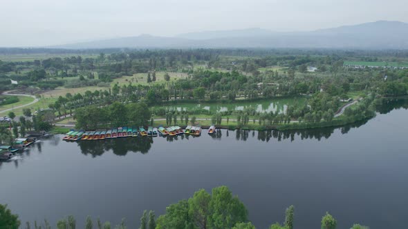 Dolly out with jib up above highway with aproaching to natural area and a lake in Xochimilco, Mexico