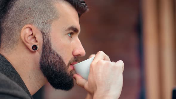 Closeup Pensive Hipster Attractive Male with Beard Thinking Drinking Fragrance Coffee Holding Cup