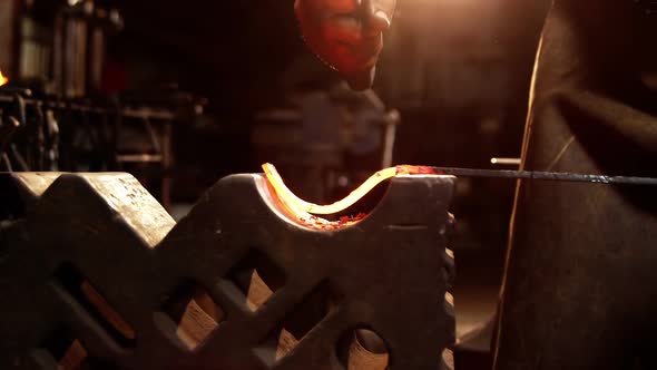 Mid-section of blacksmith working on a iron rod