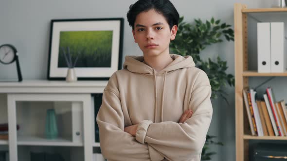 Portrait of Serious Teenager Looking at Camera with Straight Face at Home