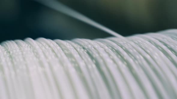 Close Up Shot of a Whitecolored Power Cable Unwinding From a Spool